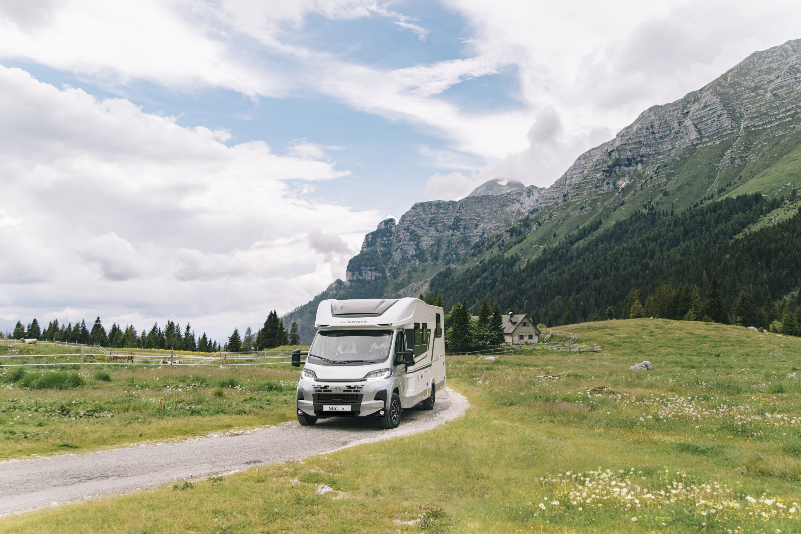 Adria Matrix Reisemobil auf einer Bergstraße, im Hintergrund Berge.